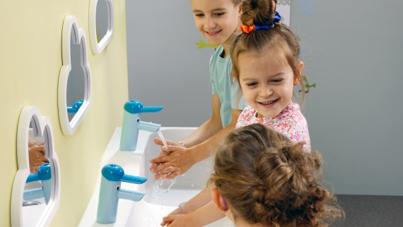 A gyerekek egy Geberit Bambini játszó- és mosakodóhelynél kezet mosnak