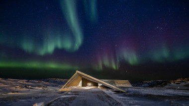 A Jégfjord Központ a grönlandi sarki éjszaka látványos északi fényeiben (© Adam Mørk)
